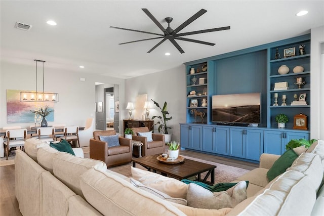 8112 Silhouette St, Austin, TX 78744 - living room featuring a ceiling fan, wood finished floors, a chandelier, and recessed lighting