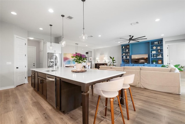 8112 Silhouette St, Austin, TX 78744 - kitchen featuring a sink, recessed lighting, a center island with sink, dishwasher, and light wood-style floors