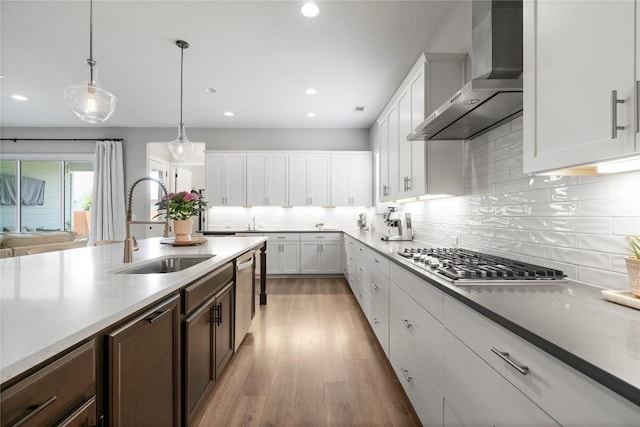 8112 Silhouette St, Austin, TX 78744 - kitchen with wall chimney exhaust hood, a sink, stainless steel appliances, backsplash, and dark brown cabinets