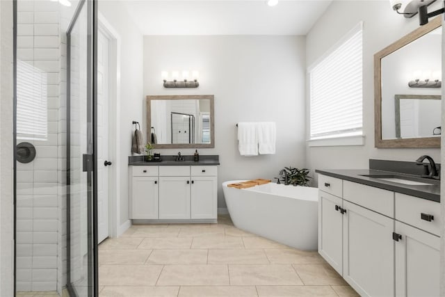 8112 Silhouette St, Austin, TX 78744 - full bathroom featuring a stall shower, a freestanding tub, two vanities, and recessed lighting