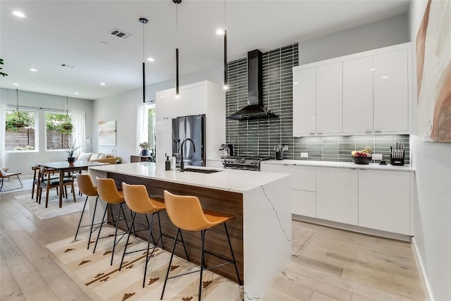 2108 Tillery St Unit 2105, Austin, TX 78723 - kitchen with wall chimney exhaust hood, modern cabinets, a sink, light wood-style flooring, and recessed lighting
