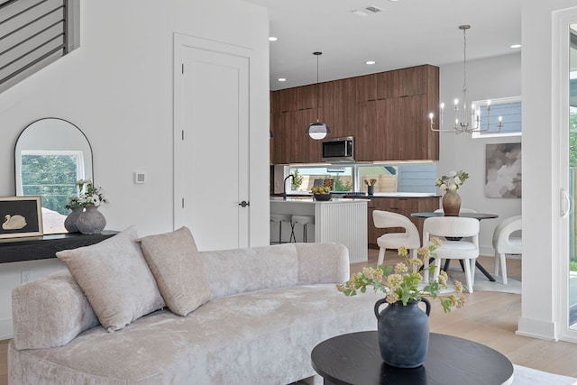 2114 Haskell St, Austin, TX 78702 - living room with a chandelier, light wood-style floors, and recessed lighting