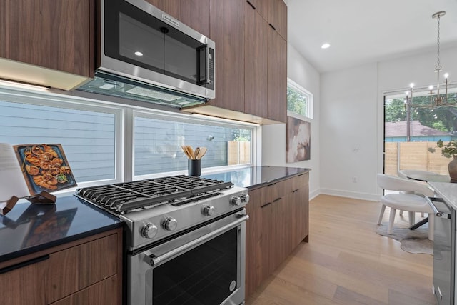 2114 Haskell St, Austin, TX 78702 - kitchen with stainless steel appliances, modern cabinets, light wood finished floors, dark countertops, and recessed lighting