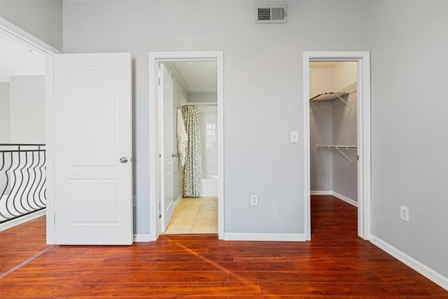 11203 Ranch Road 2222 1501, Austin, TX 78730 - unfurnished bedroom with wood finished floors, a spacious closet, baseboards, and a closet