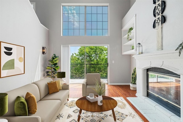 11203 Ranch Road 2222 1501, Austin, TX 78730 - living area featuring wood finished floors, a towering ceiling, and a high end fireplace