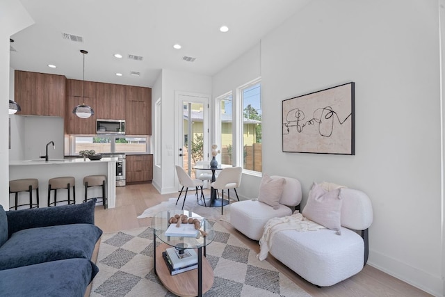 52 Robert T Martinez Jr St, Austin, TX 78702 - living room with light wood-style floors, recessed lighting, and baseboards