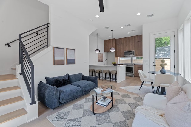 52 Robert T Martinez Jr St, Austin, TX 78702 - living room featuring stairs, light wood-type flooring, recessed lighting, ceiling fan, and baseboards
