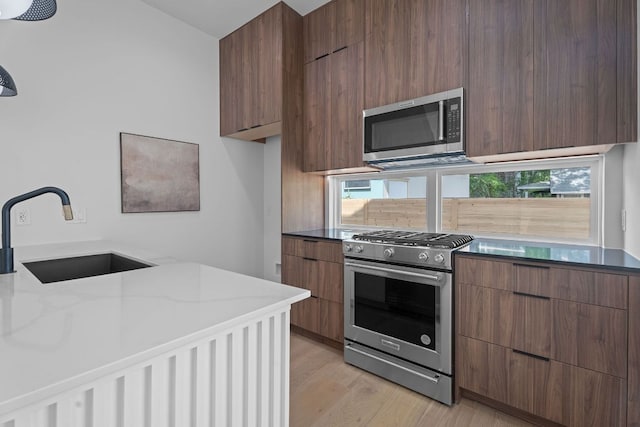 52 Robert T Martinez Jr St, Austin, TX 78702 - kitchen with appliances with stainless steel finishes, a sink, modern cabinets, and light wood finished floors