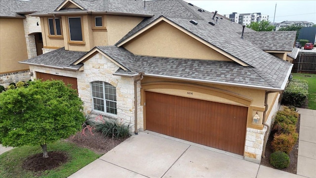 2210 Onion Creek Pkwy Unit 604, Austin, TX 78747 - view of front of house with stone siding, roof with shingles, stucco siding, and driveway