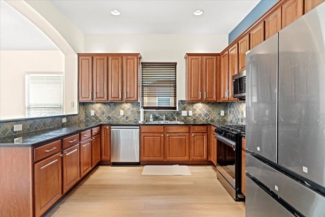 2210 Onion Creek Pkwy Unit 604, Austin, TX 78747 - kitchen with appliances with stainless steel finishes, brown cabinetry, a sink, light wood-style flooring, and recessed lighting