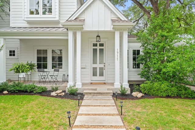 1711 Mohle Dr, Austin, TX 78703 - property entrance featuring covered porch, a standing seam roof, metal roof, board and batten siding, and a yard