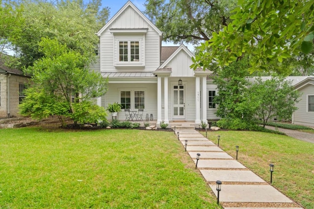 1711 Mohle Dr, Austin, TX 78703 - view of front of house with board and batten siding, a standing seam roof, a porch, and a front lawn