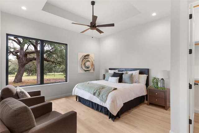 8341 Brewer Ln, Salado, TX 76571 - bedroom featuring light wood finished floors, recessed lighting, a raised ceiling, baseboards, and ceiling fan