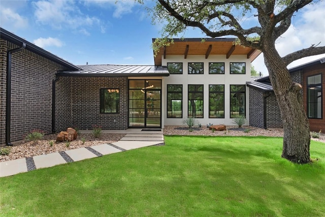 8341 Brewer Ln, Salado, TX 76571 - back of house featuring a standing seam roof, brick siding, a lawn, and metal roof