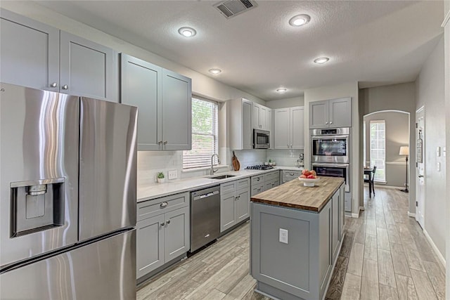 8002 Magic Mountain Cv, Round Rock, TX 78681 - kitchen featuring stainless steel appliances, wooden counters, gray cabinets, a sink, and a textured ceiling