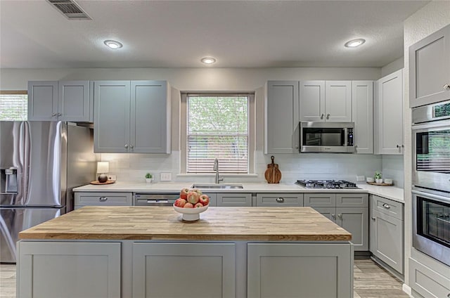 8002 Magic Mountain Cv, Round Rock, TX 78681 - kitchen featuring wooden counters, appliances with stainless steel finishes, gray cabinets, a kitchen island, and recessed lighting