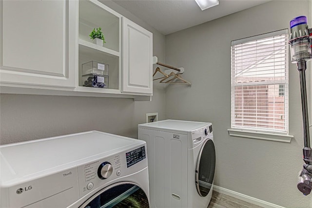 8002 Magic Mountain Cv, Round Rock, TX 78681 - washroom featuring washing machine and clothes dryer, cabinet space, and wood finished floors