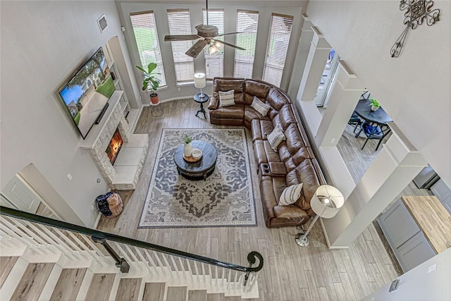 8002 Magic Mountain Cv, Round Rock, TX 78681 - living room with wood finished floors, a ceiling fan, and a fireplace