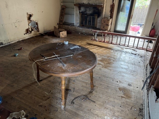 1807 Ferguson Ln, Austin, TX 78754 - unfurnished living room featuring hardwood / wood-style flooring and a brick fireplace