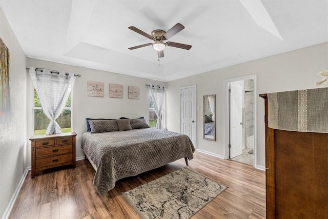 306 Southbrook Dr, Killeen, TX 76542 - bedroom with a raised ceiling, wood finished floors, baseboards, ceiling fan, and connected bathroom
