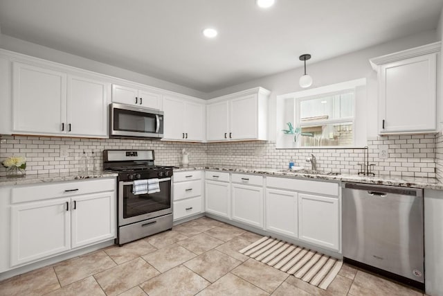2310 Windsong Trl, Round Rock, TX 78664 - kitchen featuring appliances with stainless steel finishes, a sink, white cabinetry, decorative backsplash, and light stone counters