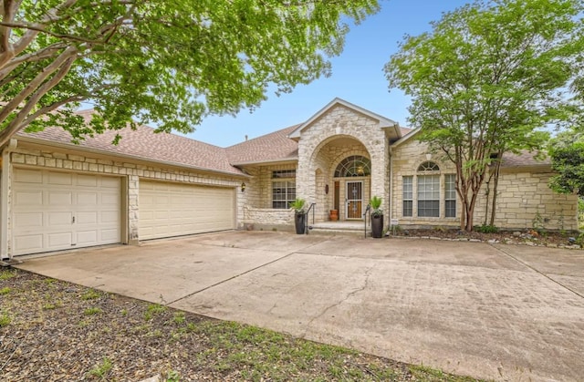 6901 W Bright Star Ln W, Austin, TX 78736 - traditional-style home featuring stone siding, concrete driveway, a garage, and a shingled roof