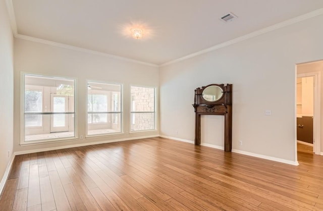 6901 W Bright Star Ln W, Austin, TX 78736 - unfurnished living room featuring healthy amount of natural light, ornamental molding, and light wood-style floors