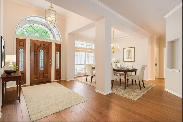 6901 W Bright Star Ln W, Austin, TX 78736 - entryway featuring a chandelier, ornamental molding, and wood-type flooring