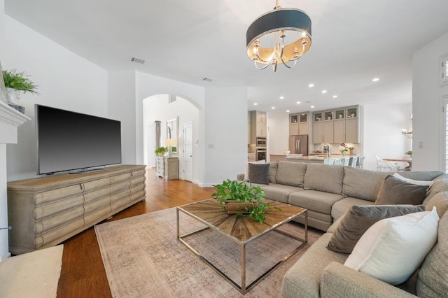 1701 Mira Vis, Leander, TX 78641 - living area featuring arched walkways, a chandelier, light wood-type flooring, and recessed lighting