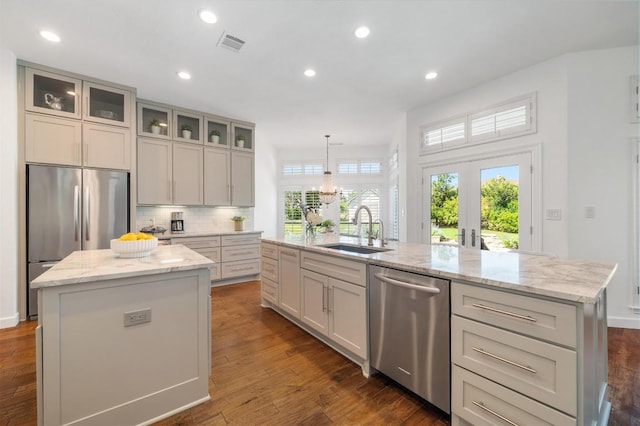 1701 Mira Vis, Leander, TX 78641 - kitchen featuring a kitchen island with sink, appliances with stainless steel finishes, light stone countertops, recessed lighting, and tasteful backsplash