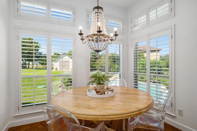 1701 Mira Vis, Leander, TX 78641 - dining area with a chandelier, baseboards, dark wood-style flooring, and a high ceiling