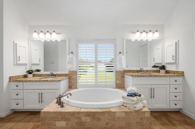 1701 Mira Vis, Leander, TX 78641 - bathroom with a garden tub, two vanities, and wood finished floors