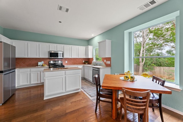 2100 Campfield Pkwy, Austin, TX 78745 - kitchen with appliances with stainless steel finishes, white cabinetry, backsplash, and dark wood finished floors