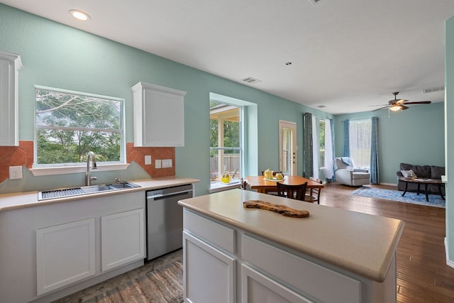 2100 Campfield Pkwy, Austin, TX 78745 - kitchen featuring stainless steel dishwasher, a sink, open floor plan, white cabinetry, and backsplash