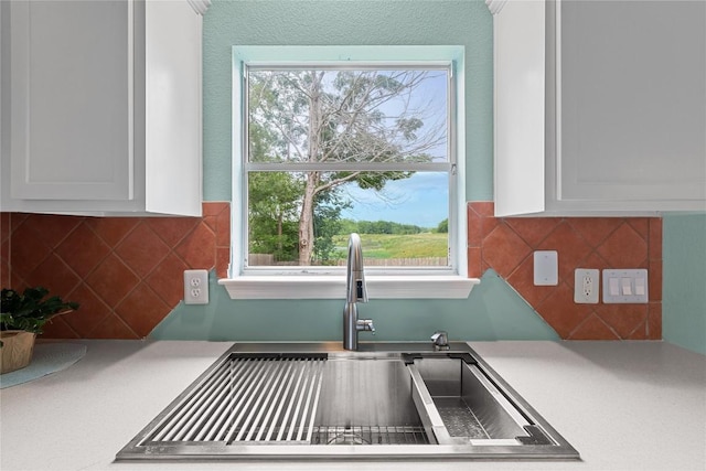 2100 Campfield Pkwy, Austin, TX 78745 - kitchen with a sink, light countertops, white cabinets, and decorative backsplash