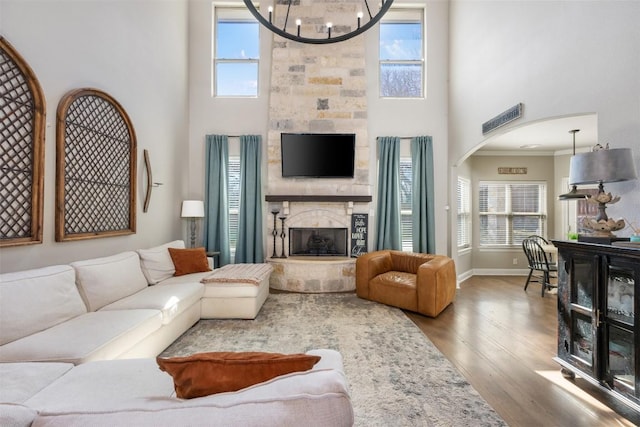 2015 Th Jones Mill Way, Salado, TX 76571 - living room featuring a towering ceiling, wood finished floors, a stone fireplace, plenty of natural light, and arched walkways
