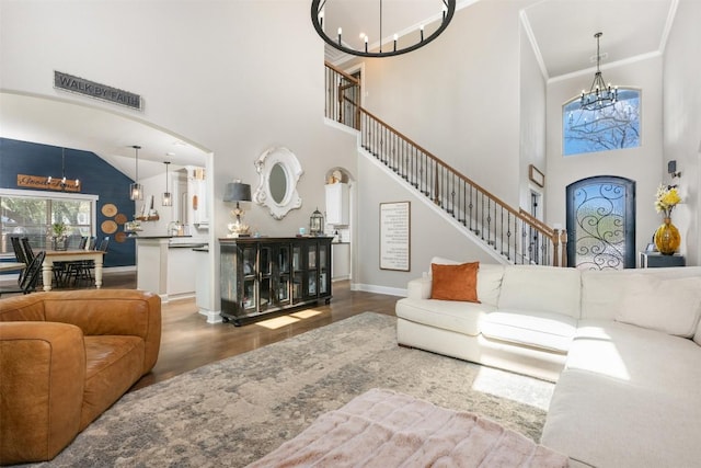 2015 Th Jones Mill Way, Salado, TX 76571 - living area featuring a chandelier, wood finished floors, arched walkways, a towering ceiling, and ornamental molding