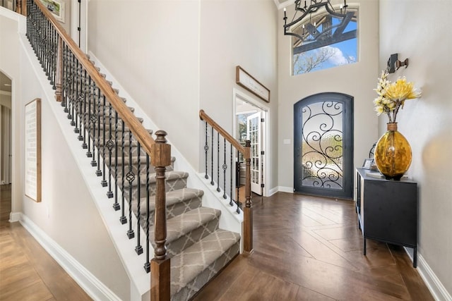 2015 Th Jones Mill Way, Salado, TX 76571 - foyer featuring a towering ceiling, parquet flooring, stairway, arched walkways, and baseboards