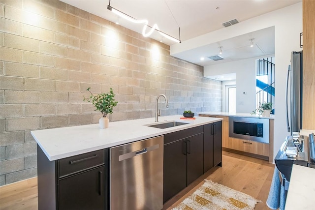 700 Denson Dr Unit 1104, Austin, TX 78752 - kitchen with stainless steel appliances, a sink, light wood-type flooring, light countertops, and tasteful backsplash