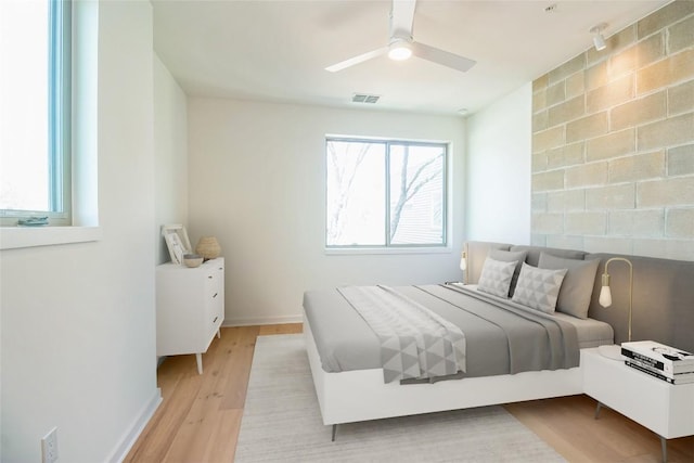 700 Denson Dr Unit 1104, Austin, TX 78752 - bedroom with light wood-style floors, baseboards, and a ceiling fan