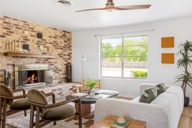 304 W Bee St, Lockhart, TX 78644 - living room featuring ceiling fan, a brick fireplace, wood finished floors, and baseboards