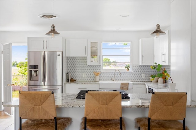 304 W Bee St, Lockhart, TX 78644 - kitchen featuring stainless steel fridge with ice dispenser, a sink, backsplash, and plenty of natural light