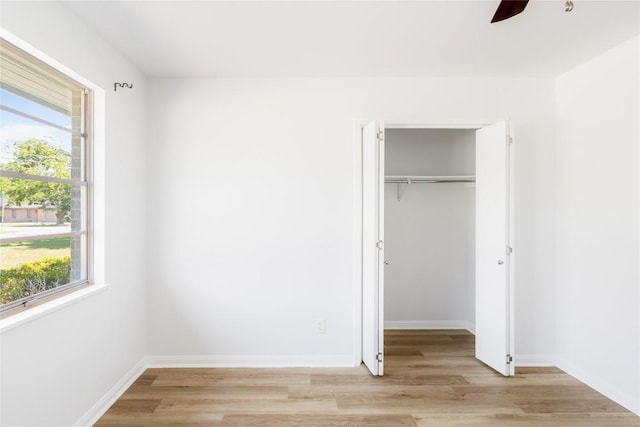 304 W Bee St, Lockhart, TX 78644 - unfurnished bedroom with light wood-style flooring, a closet, baseboards, a walk in closet, and ceiling fan
