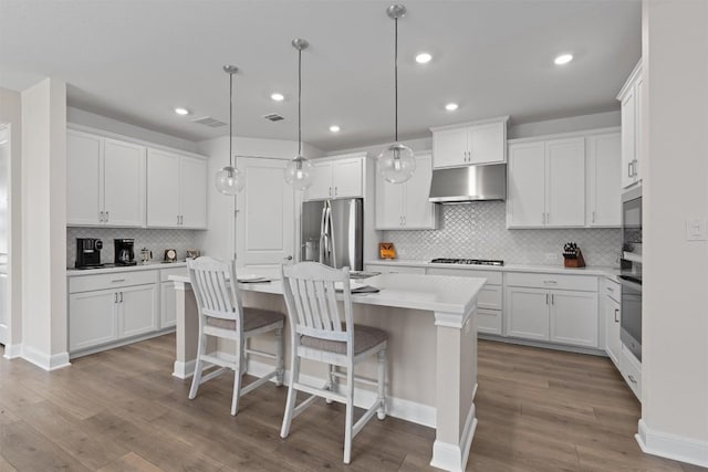 3227 Drago Dr, Round Rock, TX 78665 - kitchen featuring stainless steel fridge with ice dispenser, under cabinet range hood, backsplash, light countertops, and an island with sink