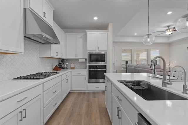 3227 Drago Dr, Round Rock, TX 78665 - kitchen with stainless steel appliances, under cabinet range hood, a sink, light countertops, and white cabinetry