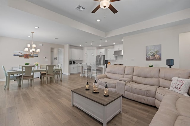 3227 Drago Dr, Round Rock, TX 78665 - living room with ceiling fan, light wood-style flooring, a chandelier, recessed lighting, and baseboards