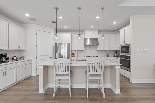 3227 Drago Dr, Round Rock, TX 78665 - kitchen with stainless steel appliances, under cabinet range hood, backsplash, a sink, and a kitchen island with sink