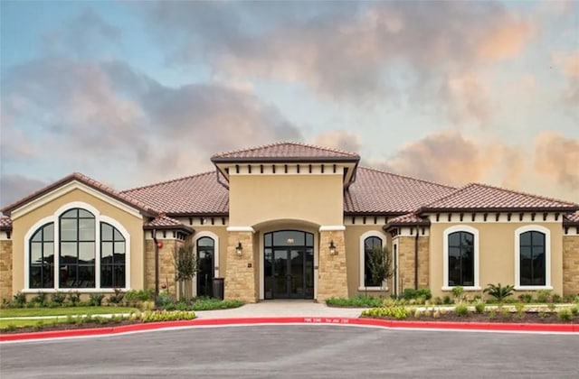 3227 Drago Dr, Round Rock, TX 78665 - mediterranean / spanish-style house featuring french doors, stucco siding, a tile roof, and stone siding