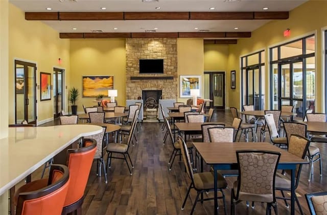 3227 Drago Dr, Round Rock, TX 78665 - dining space featuring beamed ceiling, dark wood-style flooring, a stone fireplace, recessed lighting, and a high ceiling