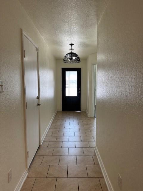 5511 Toledo Farm, San Antonio, TX 78222 - entryway featuring light tile patterned flooring, a textured ceiling, and baseboards